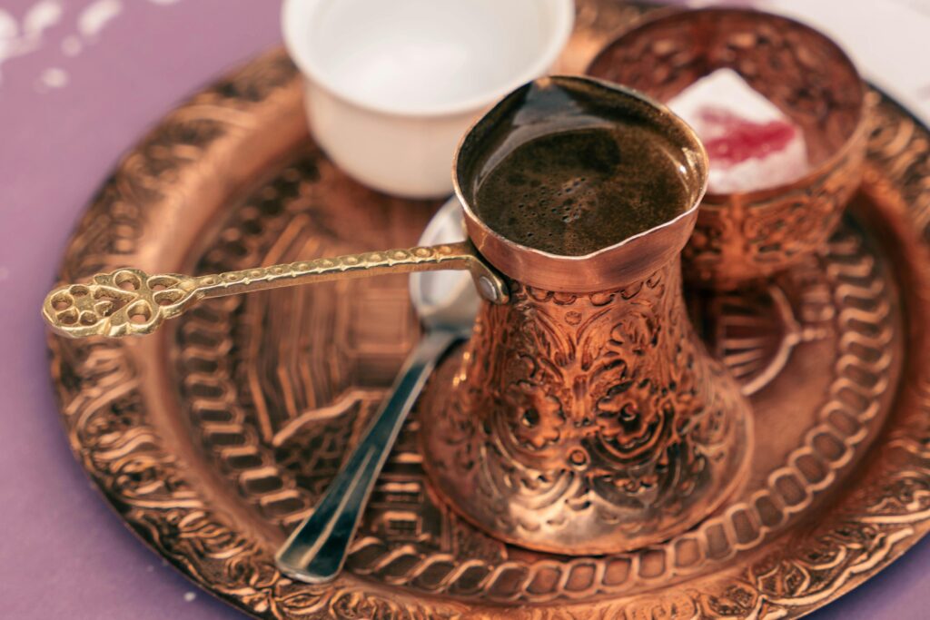 A rich, flavorful Turkish coffee served in an ornate copper set with matching accessories.