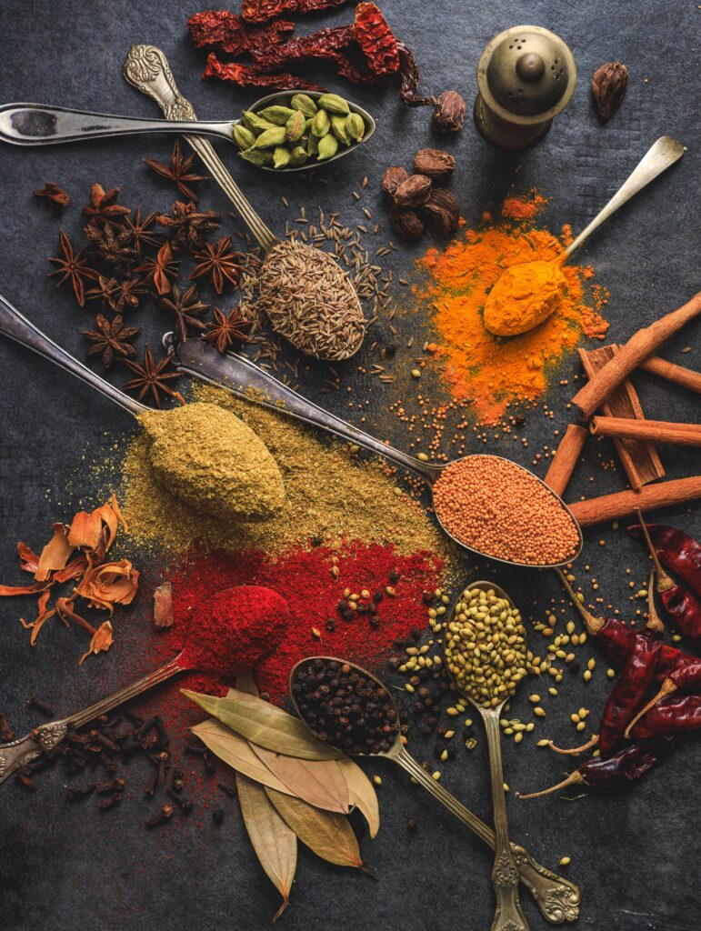 pexels photo 2802527 2802527 Vibrant array of spices including turmeric, cumin, and chili arranged on a dark surface.