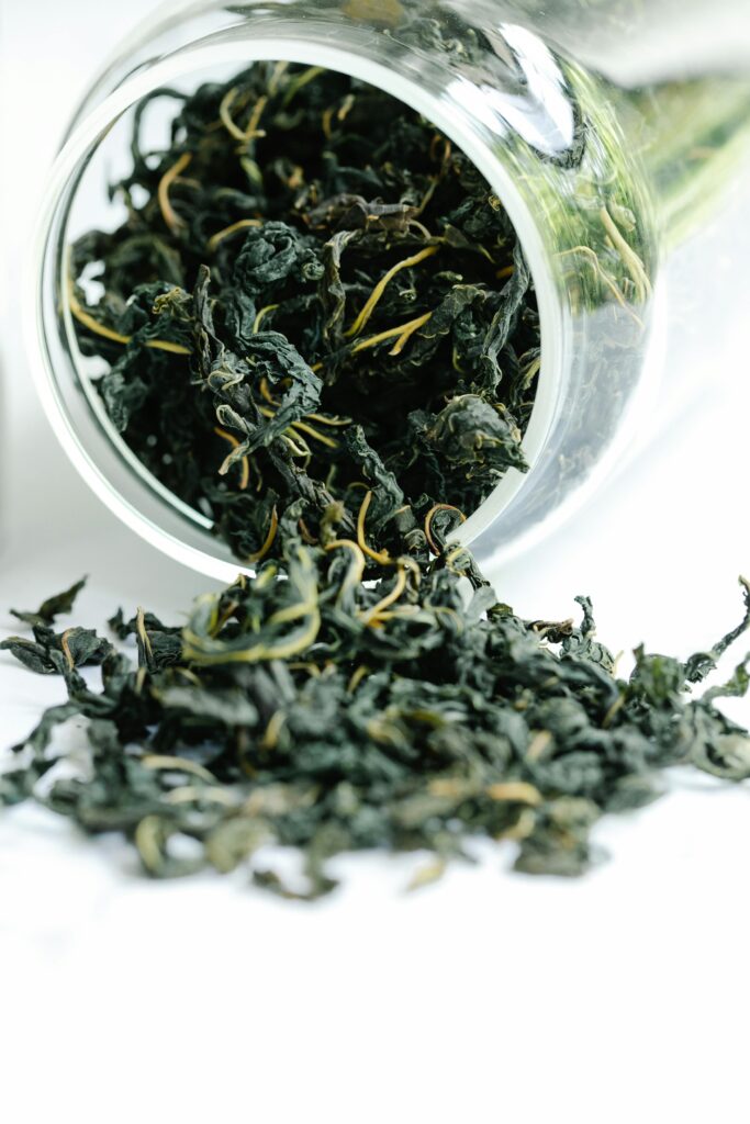 pexels photo 8329983 8329983 A close-up of dried black tea leaves spilling from a glass jar, showcasing texture and freshness.